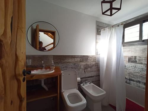 ein Badezimmer mit einem WC, einem Waschbecken und einem Spiegel in der Unterkunft Papa Ruku in Villa Ciudad Parque