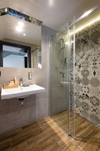 a bathroom with a sink and a shower at Ilkus Hotel & Restaurant in Krze