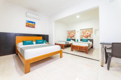 a bedroom with two beds and a table at Ayenda Zhena in Cúcuta