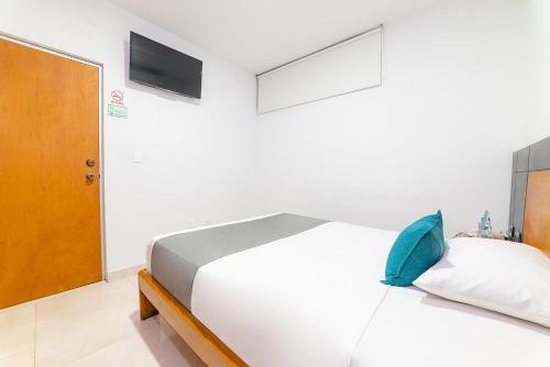 a bedroom with a white bed and a television at Ayenda Zhena in Cúcuta