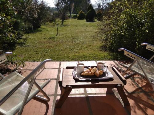 une table de pique-nique avec un plateau de nourriture et deux chaises dans l'établissement Pilmaiquen, à Riachuelo