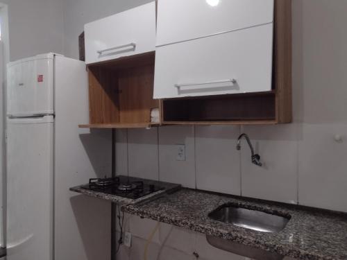 uma cozinha com um lavatório e um frigorífico branco em kitnet em cabo frio 01 em Cabo Frio