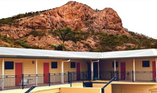 a large stone building with a view of a mountain range at Summit Motel in Townsville