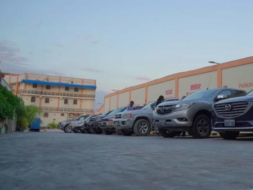 a row of cars parked in a parking lot at La Pepiniere Hotel in Petionville