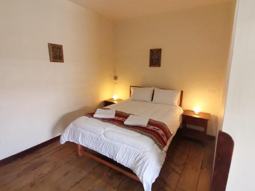 Un dormitorio con una cama con dos luces. en Hugos house en Cusco