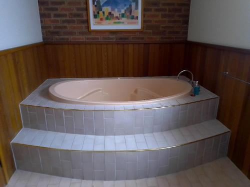 a bath tub in a room with a brick wall at Kerang Motel in Kerang