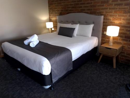 um quarto de hotel com uma cama grande e duas lâmpadas em Kerang Motel em Kerang