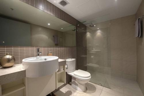 a bathroom with a toilet and a sink and a shower at ZEN CITY & SEA Executive 1-BR Suite in Darwin CBD in Darwin