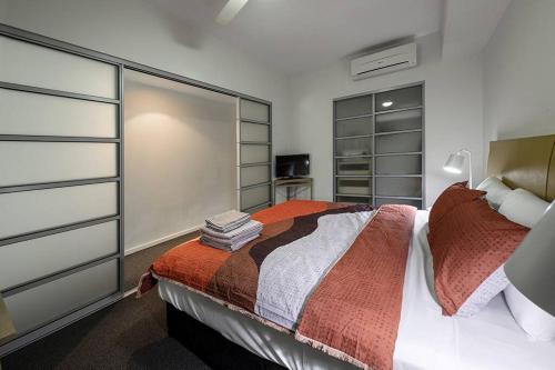 a bedroom with a bed and some shelves at ZEN CITY & SEA Executive 1-BR Suite in Darwin CBD in Darwin