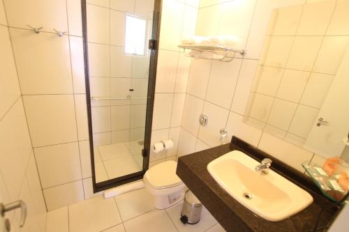 ein Bad mit einem Waschbecken, einem WC und einer Dusche in der Unterkunft Hotel Confiance Batel in Curitiba