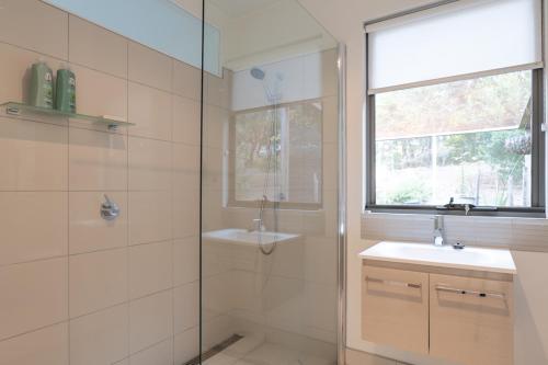 a bathroom with a shower and a sink and a mirror at Bruny Island Escapes and Hotel Bruny in Alonnah