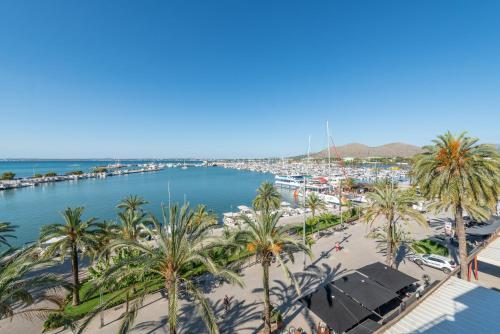 a view of a beach with palm trees and a harbor at Apartment Antonia - Alcúdia in Alcudia