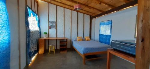 Habitación pequeña con cama y escritorio. en Casa Naranja, en Máncora