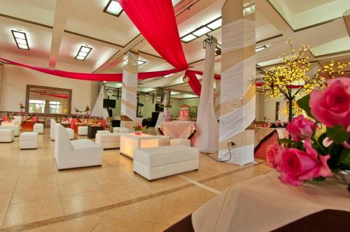 a lobby with white couches and flowers in a room at Villa Las Margaritas Caxa in Xalapa