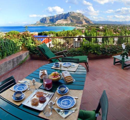 a table with plates of food on top of a patio at Il Glicine sul Golfo in Mondello