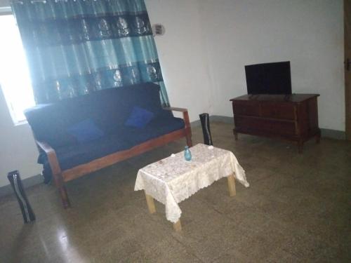 a bedroom with a bed and a table and a tv at Belretiro Cottage in Ocho Rios