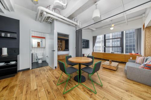 a living room with a table and chairs and a couch at Placemakr Wall Street in New York