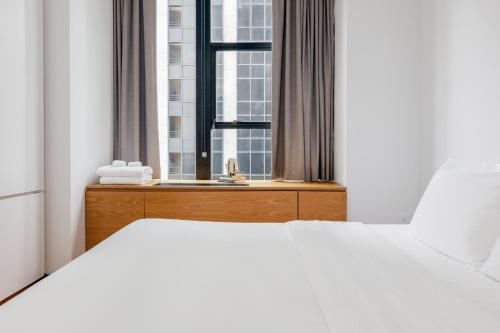 a bedroom with a white bed and a window at Placemakr Wall Street in New York