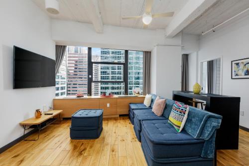 a living room with a blue couch and a tv at Placemakr Wall Street in New York