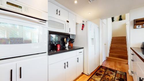 a kitchen with white cabinets and a staircase at Snowcreek #840 condo in Mammoth Lakes