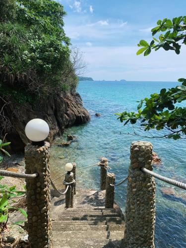 a view of the ocean from a pier with rocks at Koh Chang Hut Hotel in Ko Chang