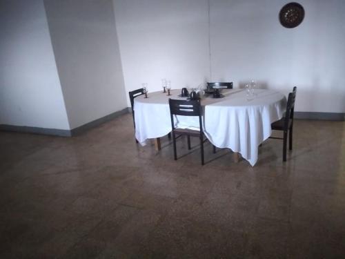 uma mesa com cadeiras e uma toalha de mesa branca em Belretiro Cottage em Bel Retiro