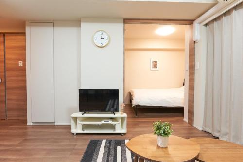 a living room with a television and a bed at HIZ HOTEL Ginza in Tokyo