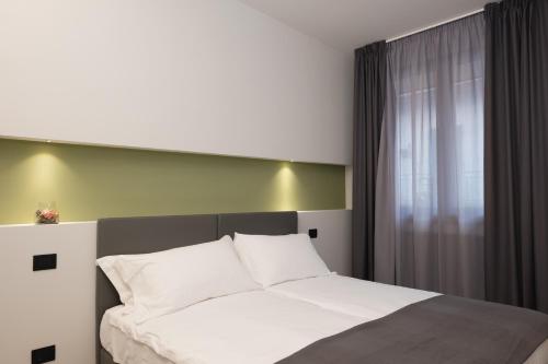 a bedroom with a bed with white sheets and a window at Amiata Suite in Abbadia San Salvatore