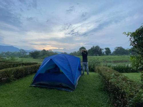 a man standing next to a blue tent at The Midst by The M - Nakhon Nayok TMD4 in Ban Som Phung Haeng (1)