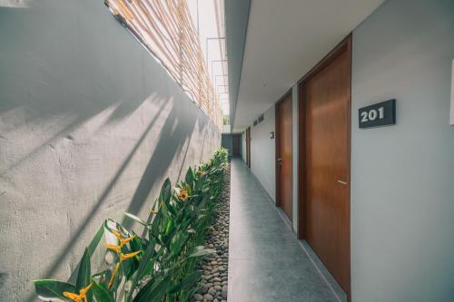 Bestah Coliving في سانور: ممر مكتب به نباتات ولافتة مكتوب عليها
