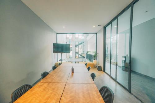 Una sala de conferencias con una larga mesa de madera y sillas. en Bestah Coliving, en Sanur
