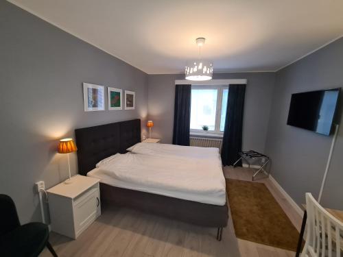 a bedroom with a large bed and a television at Hotell BOULOGNE in Gävle
