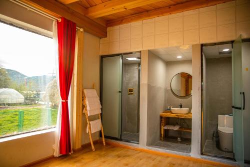 a bathroom with a shower and a toilet and a window at Aurora Hotel in Shangri-La
