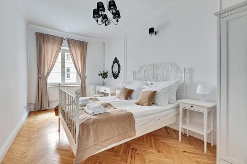 a white bedroom with a bed and a window at Downtown Apartments Old Town View - Green Gate in Gdańsk