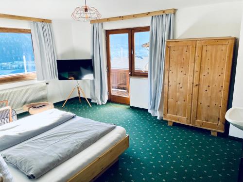 um quarto com uma cama, um lavatório e uma janela em Königin Serles - großzügig, gemütlich & nachhaltig em Fulpmes