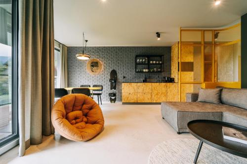 a living room with a couch and a chair at Apartamenty Riders Lodge Szczyrk Kalinowa in Szczyrk