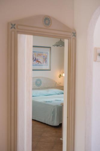 a bedroom with a bed in a room with a mirror at Le Residenze del Golfo di Orosei in Orosei