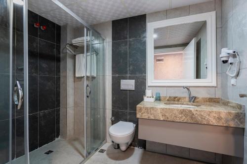 y baño con aseo, lavabo y ducha. en TAMARA Business Otel, en Antalya