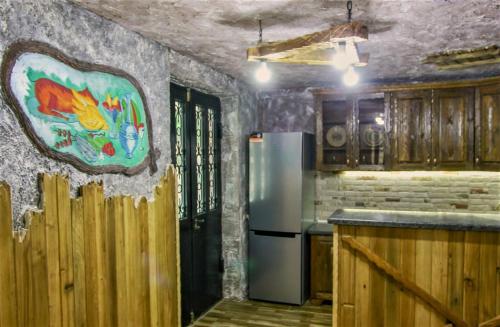 kuchnia z lodówką i obrazem na ścianie w obiekcie Mango's Guesthouse w Kutaisi