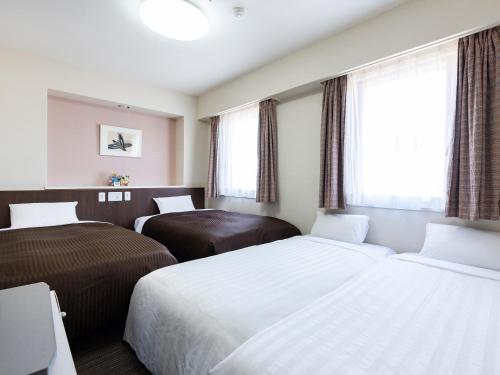 Postel nebo postele na pokoji v ubytování Hotel Wing International Izumi