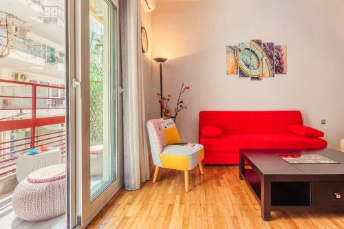 a living room with a red couch and a table at Cuckoo's Nest - Kalamata City Centre Luxury in Kalamata