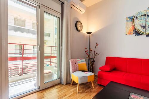 a living room with a red couch and a window at Cuckoo's Nest - Kalamata City Centre Luxury in Kalamata