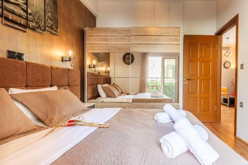 a bedroom with two beds and a mirror at Cuckoo's Nest - Kalamata City Centre Luxury in Kalamata