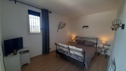 um quarto com uma cama e uma televisão de ecrã plano em Appartement domaine du Golf de Roquebrune Resort - Résidence Le Saint Andrews em Roquebrune-sur-Argens