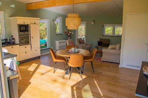 uma cozinha e sala de estar com mesa e cadeiras em Farmhouse Lodge Giethoorn em Giethoorn