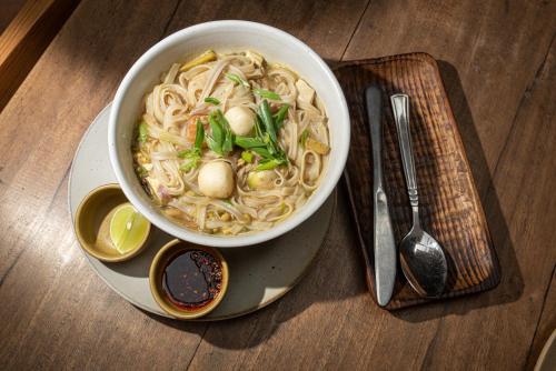 a bowl of noodle soup sitting on a plate at Peacock Guest House in Bhaktapur