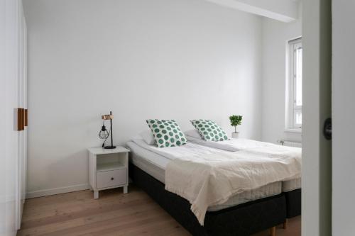 a white bedroom with a bed and a window at 2ndhomes Loft Apartment with Spa & Balcony by the White Church in Helsinki