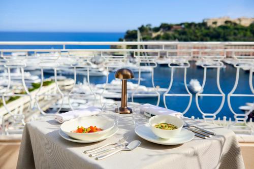 a table topped with plates of food on top of a beach at Hôtel Hermitage Monte-Carlo in Monte Carlo