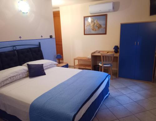 a bedroom with a bed and a table and a blue cabinet at B&B Renzano bedrooms in Salò