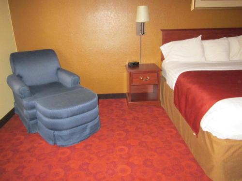 a hotel room with a bed and a chair at AmericInn by Wyndham West Bend in West Bend